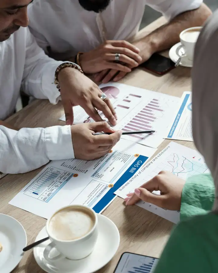 Professionals reviewing printed financial reports around a table