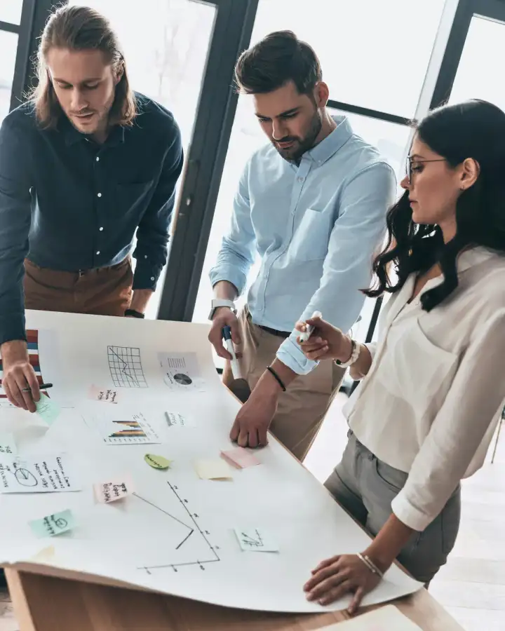 Three professionals reviewing a plan together at a table