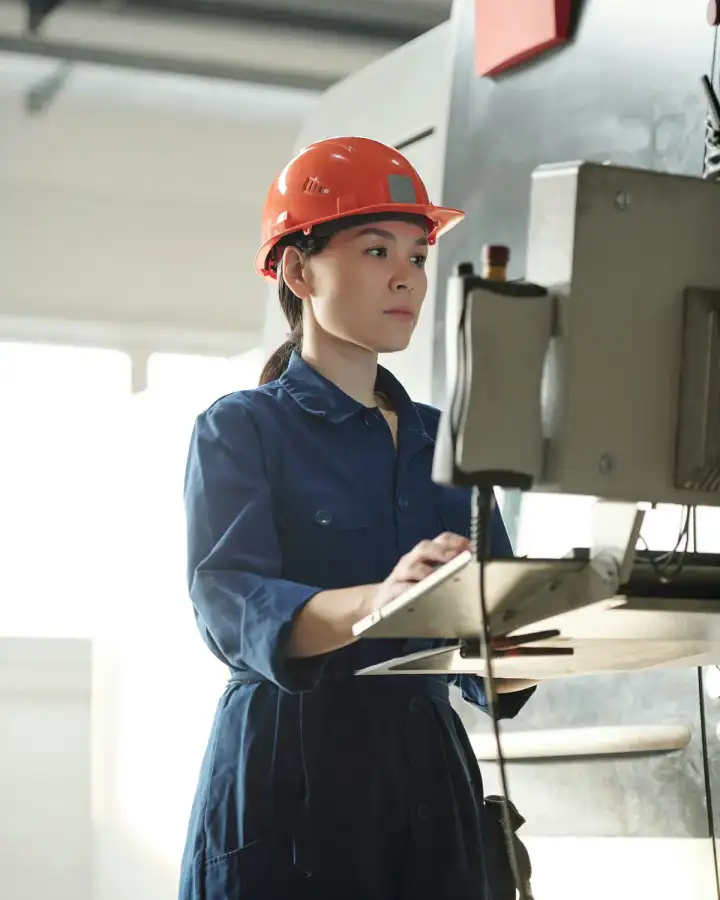 Technical specialist recording information beside industrial equipment